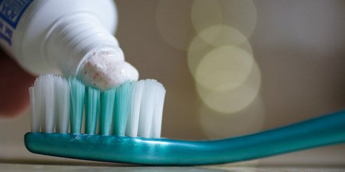 toothpaste being applied on toothbrush