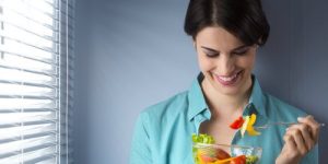 a woman teasing her salad before eating it