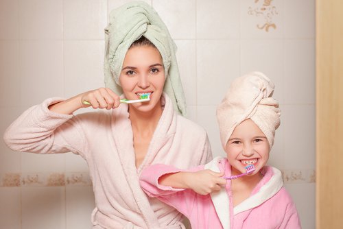 mother and child are brushing their teeth