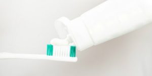 Toothpaste is being applied to a toothbrush